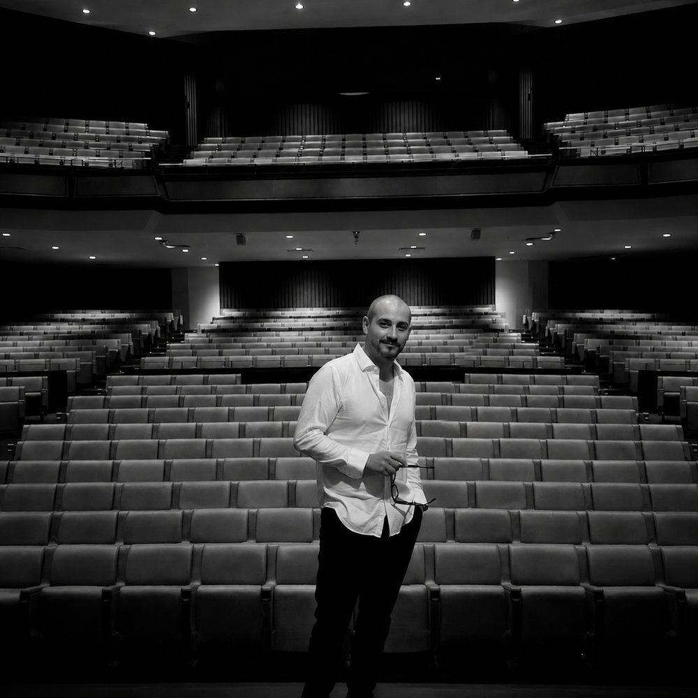 Benny Rod, Mexican tenor and vocal coach, standing in an empty theatre auditorium